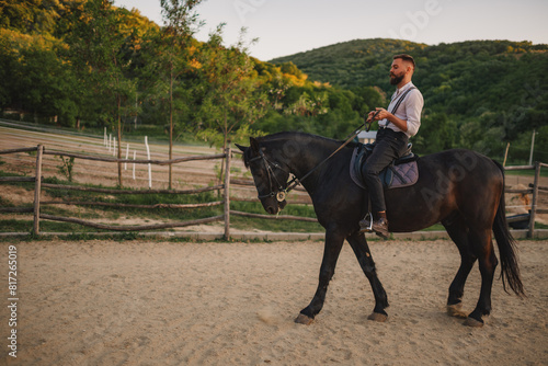 Side view of an equestrian horseback riding at rural ranch in mountains