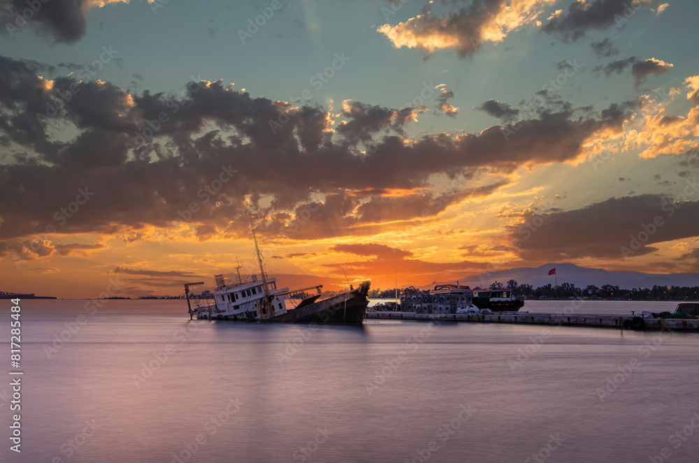 Naklejka premium Sunken cargo ship lying on its side at sunset in Aliaga Bay, Izmir.
