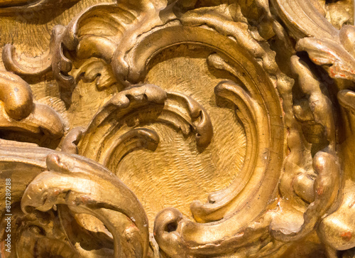 Fragment of an ancient gold picture frame, wood carving close-up. An expensive antique frame.