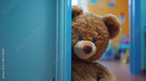 A cute brown Teddy bear peeks out from behind the door ready to surprise and celebrate the special holiday festivities It s all part of the playful game at the daycare center where kids eage photo