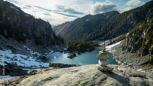 Inukshuk on cliff by mountain lake