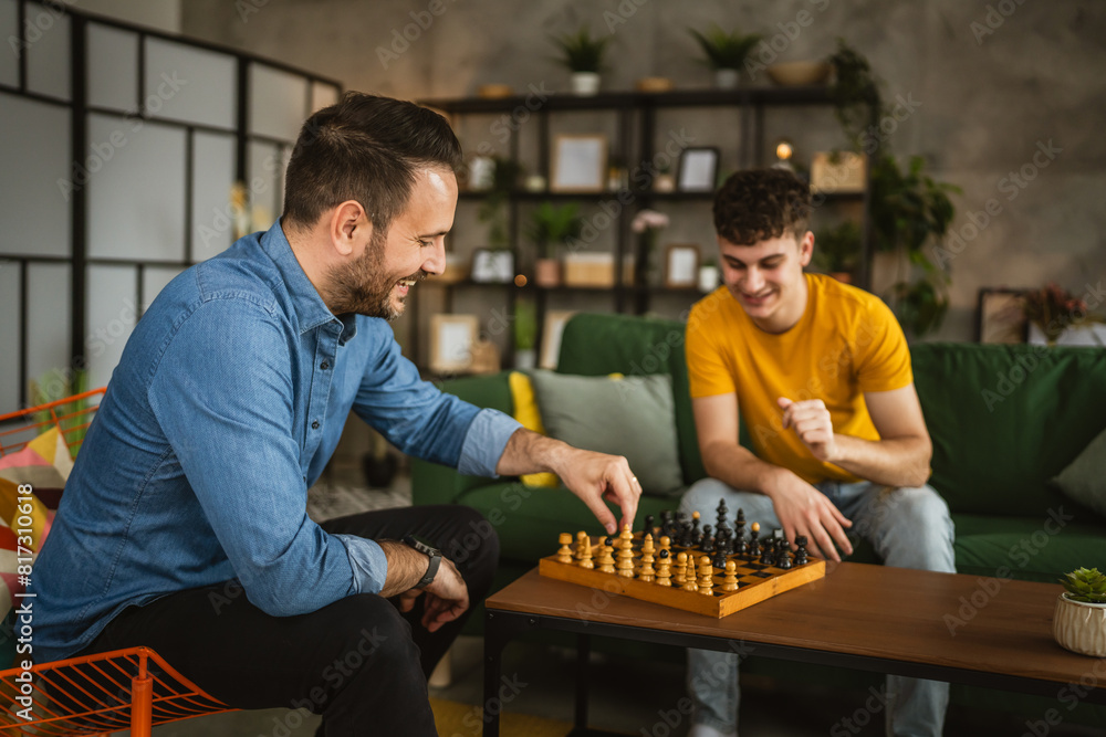 Two male friends brothers play chess together at home Two male friends brothers play chess together at home