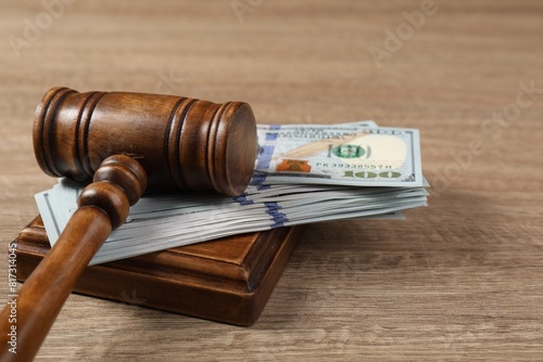 Judge's gavel and money on wooden table, closeup