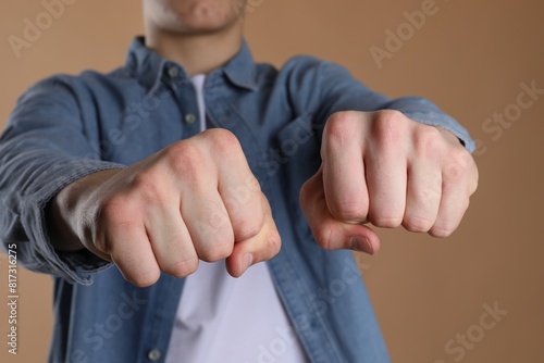 Man showing fists with space for tattoo on beige background, selective focus photo