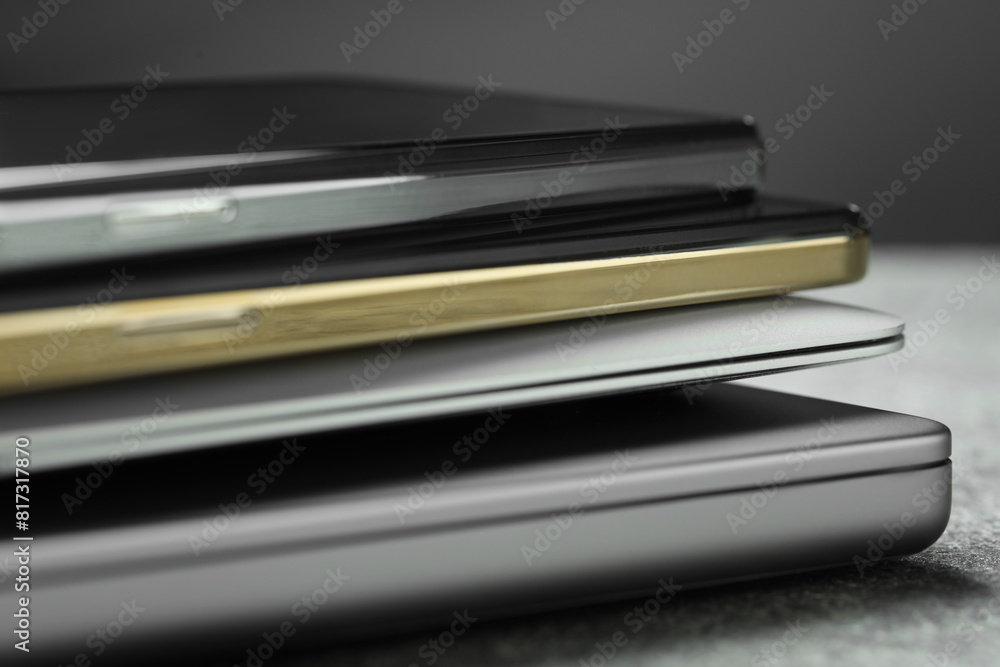 Stack of electronic devices on grey table, closeup Stack of electronic devices on grey table, closeup