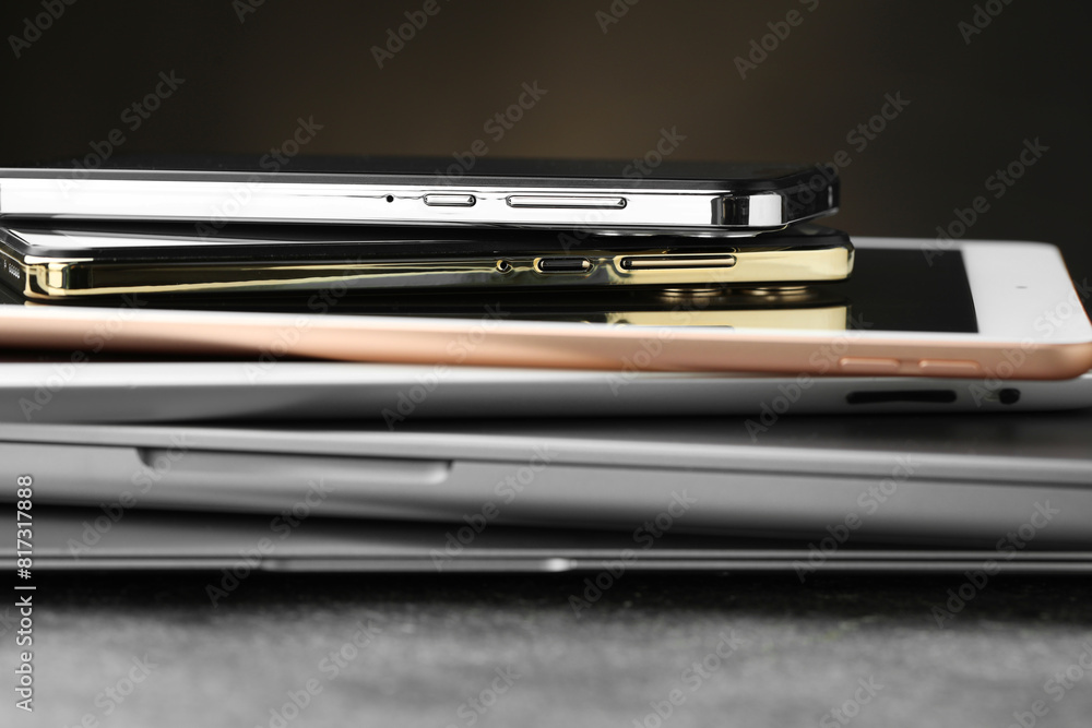 Stack of electronic devices on grey table, closeup Stack of electronic devices on grey table, closeup