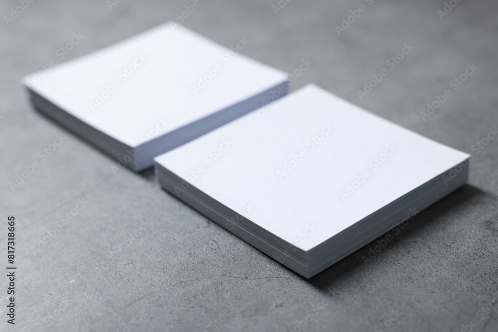 Blank paper sheets on grey textured table, closeup. Mockup for design Blank paper sheets on grey textured table, closeup. Mockup for design