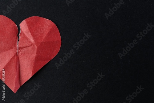 Crumpled torn paper heart on black background, top view with space for text. Breakup concept