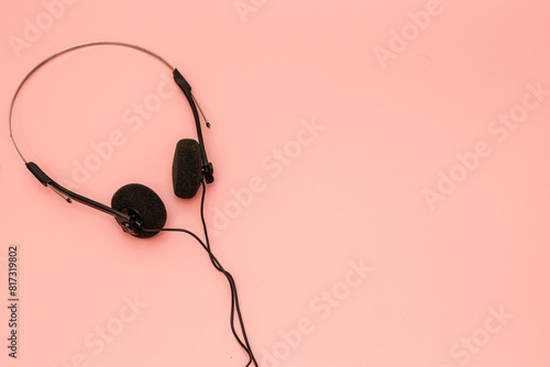 A pair of 1990's style headphones on a pink background retro vintage music concept image