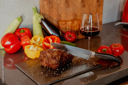 Steak and vegetables with a glass of red wine on the table photo