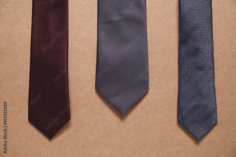 Different neckties on beige background, top view Different neckties on beige background, top view