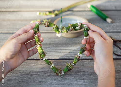 Step 4. Make a heart shape from dandelions garland. Creative crafts with natural material. Simple DIY concept.	