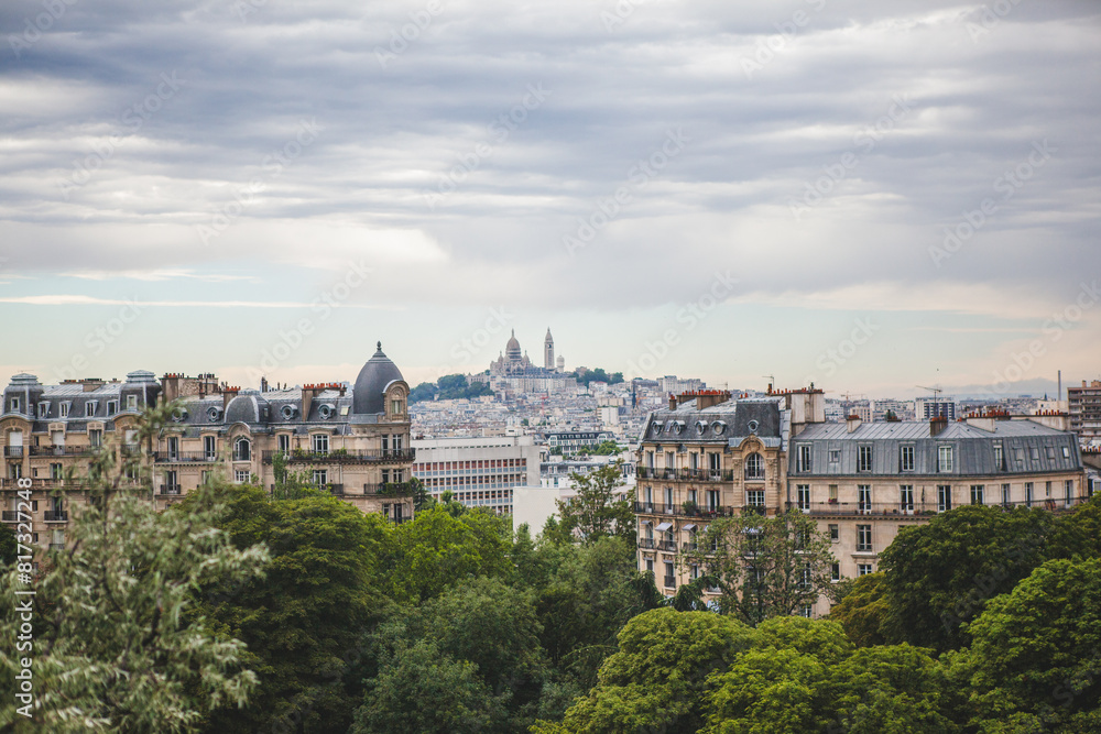 Naklejka premium View of Montmartre from the Parc des Buttes Chaumont in Paris, France on an Overcast Day