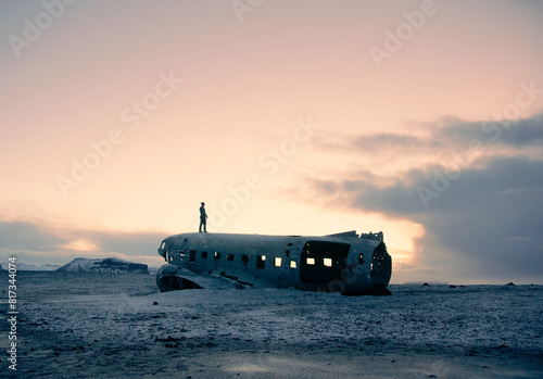 Person on abandoned airplane wreckage in Iceland at dusk photo