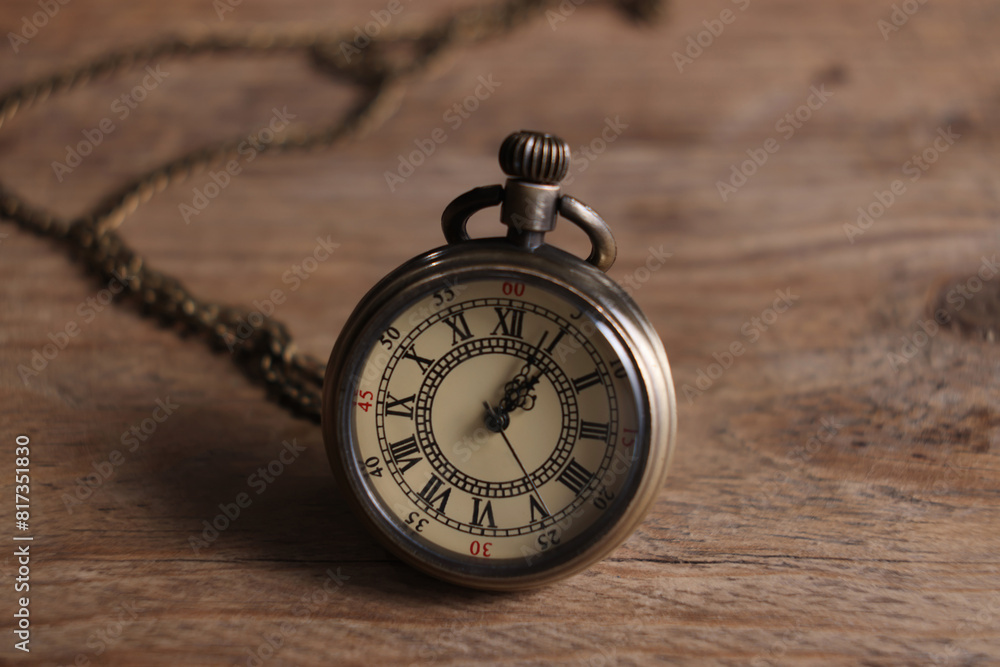 Pocket clock with chain on wooden table, closeup Pocket clock with chain on wooden table, closeup