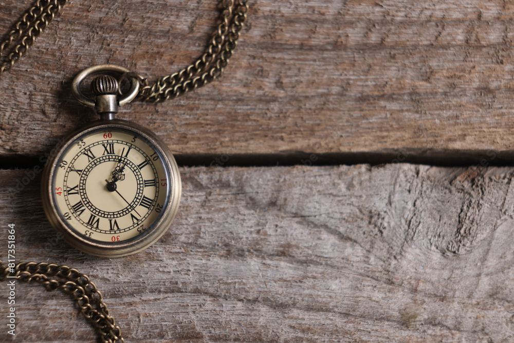 Pocket clock with chain on wooden table, top view. Space for text Pocket clock with chain on wooden table, top view. Space for text