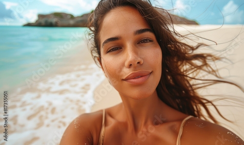 Beautiful young woman is taking selfie resting on white sand beach © piai
