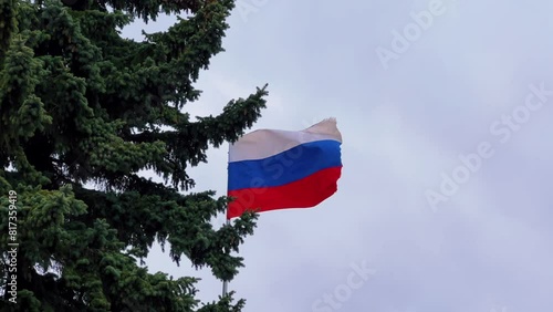 The Russian flag flutters in the wind on the Champ de Mars in St. Petersburg. There is a monument to the fighters for the revolution in the center of the square.A memorial with the flag of the country photo