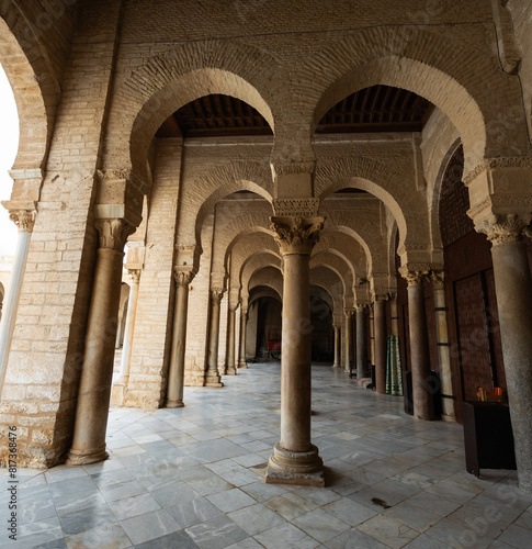 Long corridors under vaulted ceiling in ancient mosque of Kairouan in Tunisia. Colonnade in patio of Islamic temple. Religious Islamic building  place of worship prayer for many generations of Muslims
