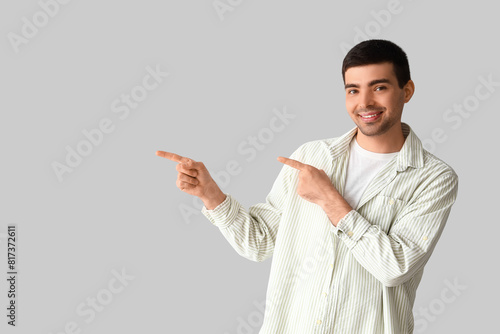 Young man pointing at somet...