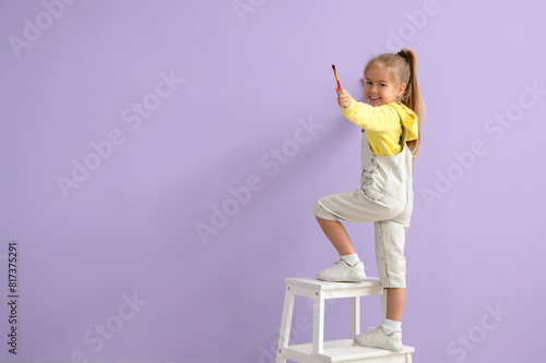 Cute little girl painting o...