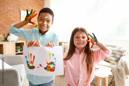 Cute little children in paint with drawing at home