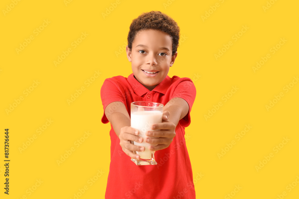 Little African-American boy with glass of milk on yellow background Little African-American boy with glass of milk on yellow background