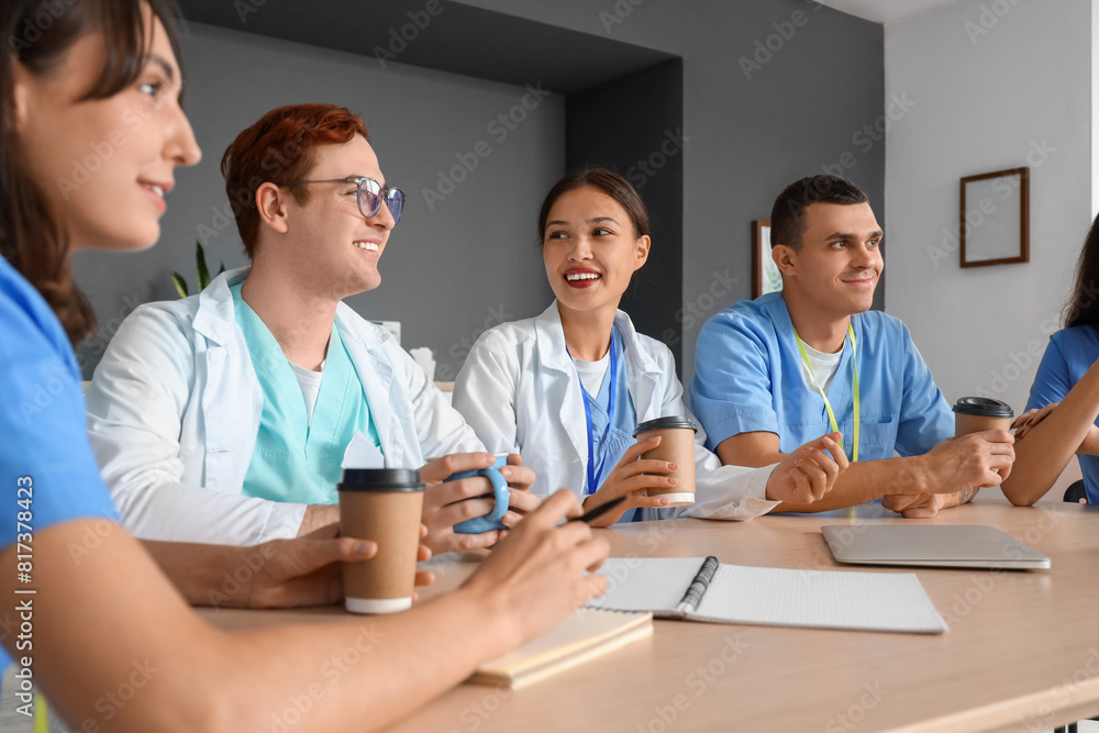 Team of young doctors having lunch at table in hospital kitchen Team of young doctors having lunch at table in hospital kitchen