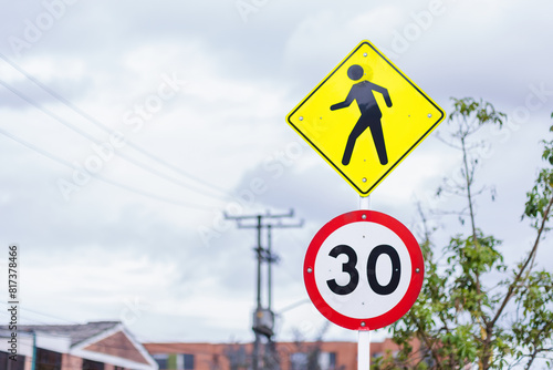 Caution traffic signs with the crossing of people and maximum speed of 30 kilometers