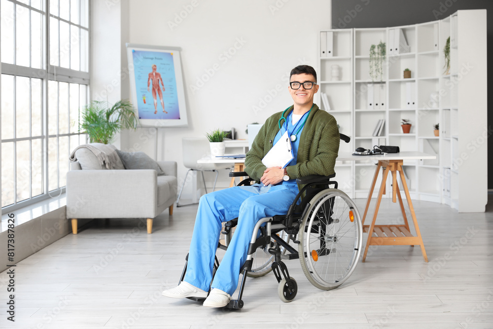 Young male doctor in wheelchair with clipboard at hospital Young male doctor in wheelchair with clipboard at hospital