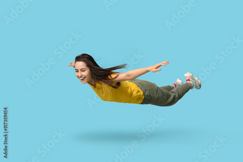 Joyful young woman flying o...