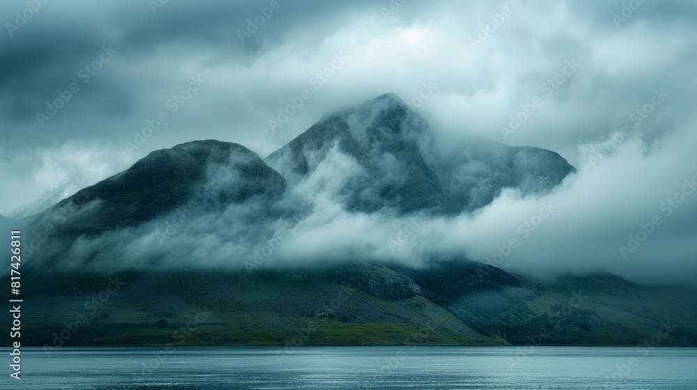 The misty clouds hovering over the mountaintop adding a sense of mystery to the already striking scenery. The misty clouds hovering over the mountaintop adding a sense of mystery to the already striking scenery.