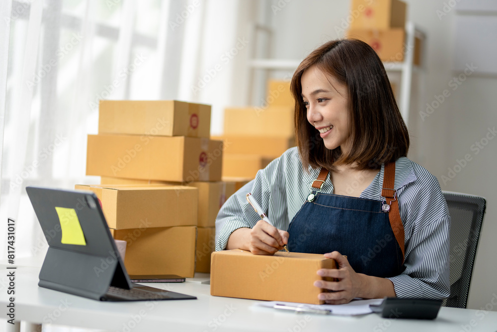 A woman is writing on a box with a pen A woman is writing on a box with a pen