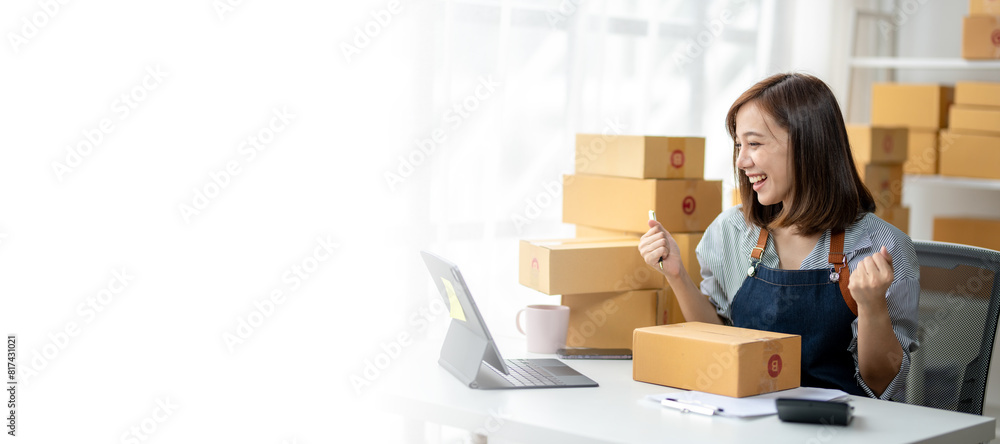 A woman is sitting at a desk with a laptop and a stack of boxes in front of her A woman is sitting at a desk with a laptop and a stack of boxes in front of her