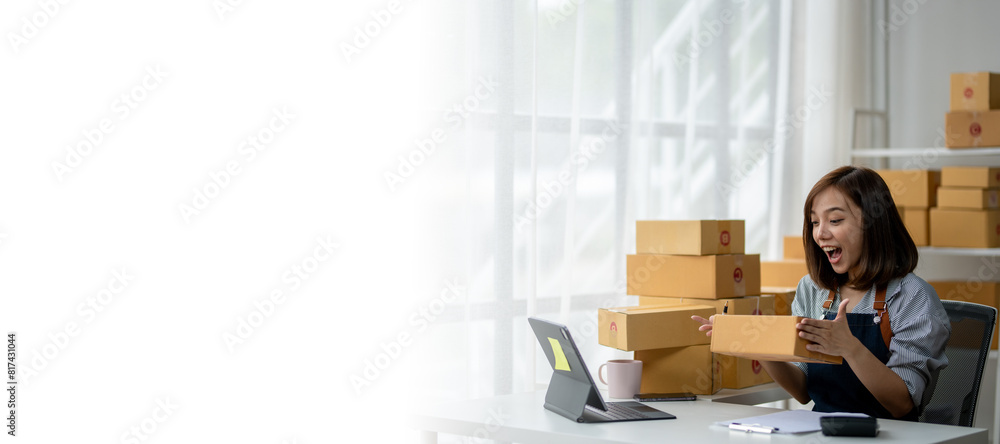 A woman is sitting at a desk with a laptop and a box in front of her A woman is sitting at a desk with a laptop and a box in front of her
