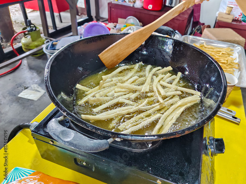 the process of frying potato sticks in hot and boiling oil
