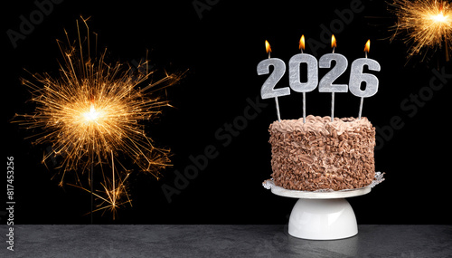 Cake with happy new year 2026 candles on black background