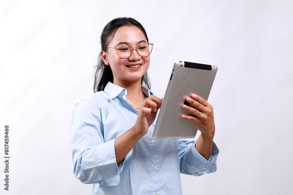 Smiling busy young asian business woman manager using tablet computer, happy business woman executive looking at tab device analyzing finance trading market data working standing over white background Smiling busy young asian business woman manager using tablet computer, happy business woman executive looking at tab device analyzing finance trading market data working standing over white background