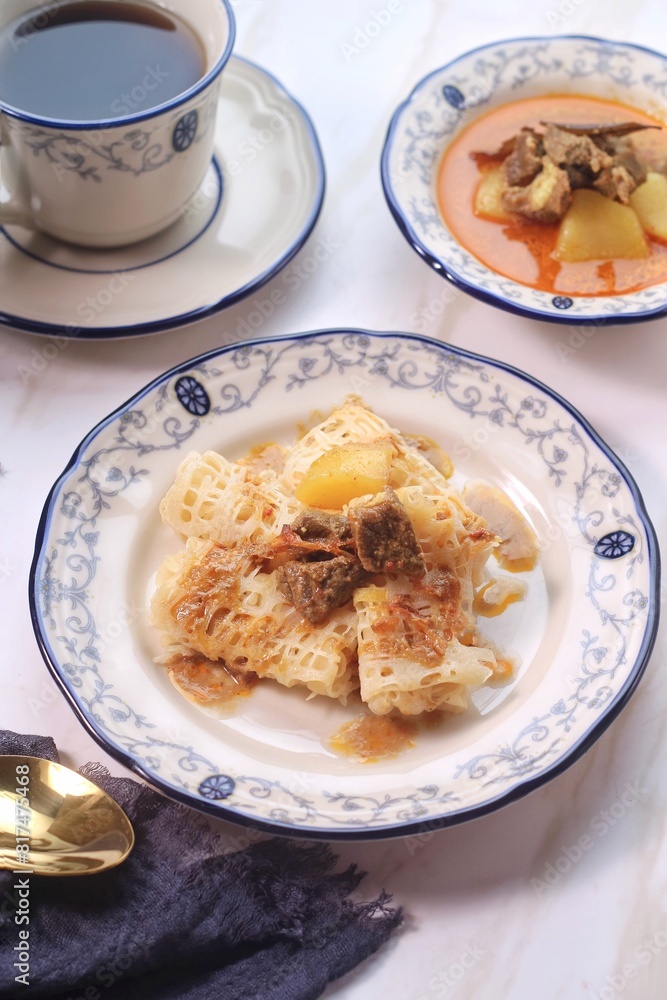 Roti Jala or Lace pancake is Indonesian traditional food served with curry dishes
Roti Jala or Lace pancake is Indonesian traditional food served with curry dishes