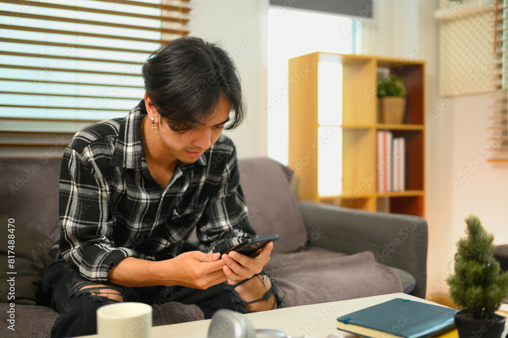 Young man browsing internet and texting online on mobile phone Young man browsing internet and texting online on mobile phone