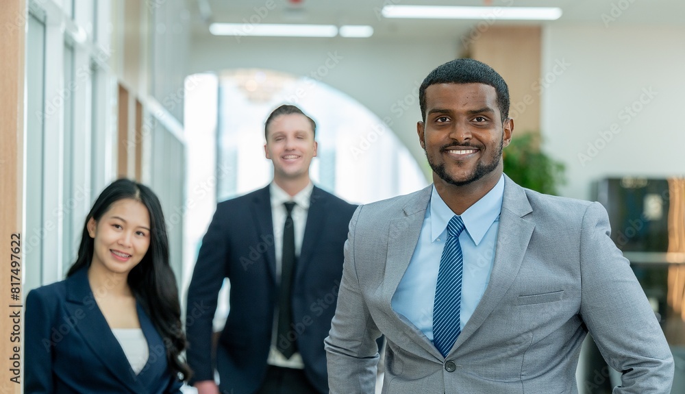 A group of business professionals in suits smiling at the camera. A group of business professionals in suits smiling at the camera.