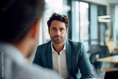 confident businessman looking at male colleague in office