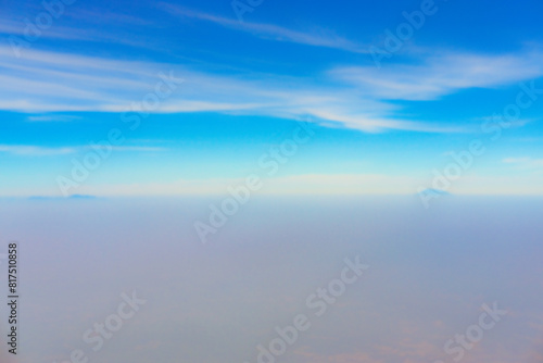 view of the bright blue sky and mountains on the island of Java from the plane window, blue sky with clouds, See Through Plane Window With Blue Sky And Clouds Outside, travel trip over Java island