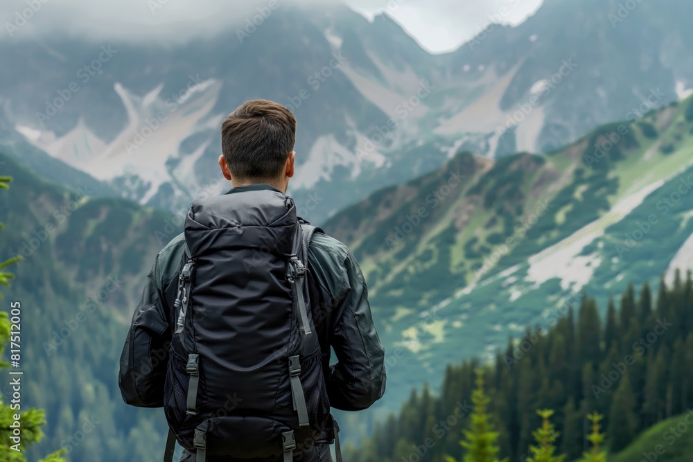 A hiker observes the beauty of a cloudy mountain landscape
