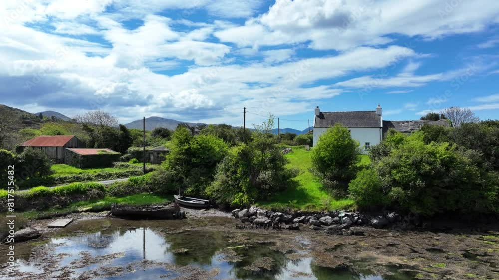 Irish landscape old pretty farmhouse with little boats moored in a creek West Cork Ireland Irish landscape old pretty farmhouse with little boats moored in a creek West Cork Ireland