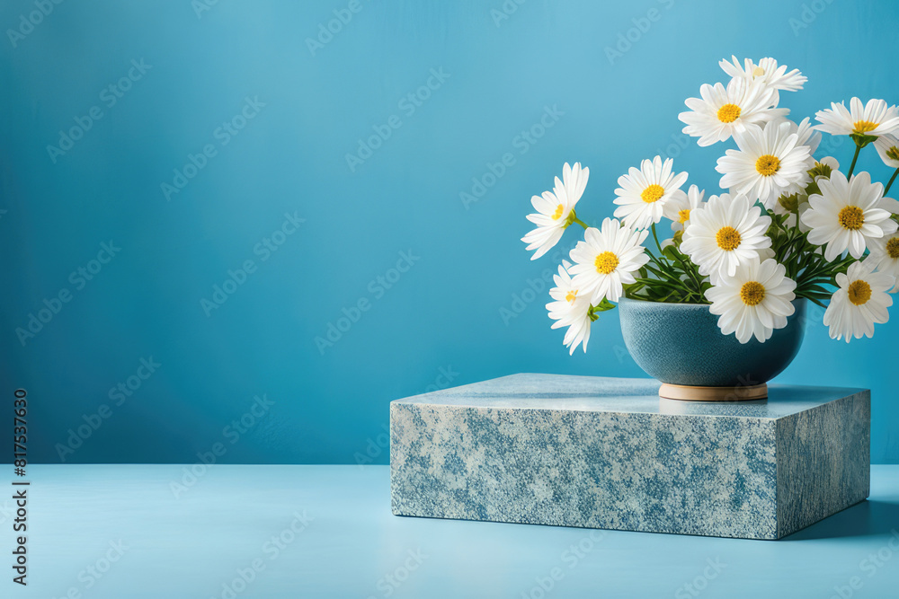 Flat granite pedestal and white flowers on blue background. Stone stand for natural design concept. Horizontal image, center composition, hard light, front view Flat granite pedestal and white flowers on blue background. Stone stand for natural design concept. Horizontal image, center composition, hard light, front view