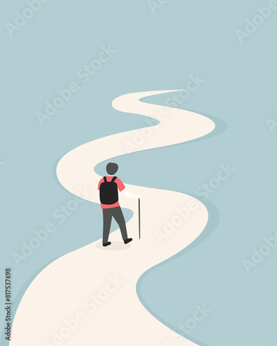 A manwith backpack and hiking pole is walking along a winding path.