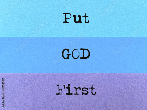 Put God first text on multicoloured paper background. Stock photo.