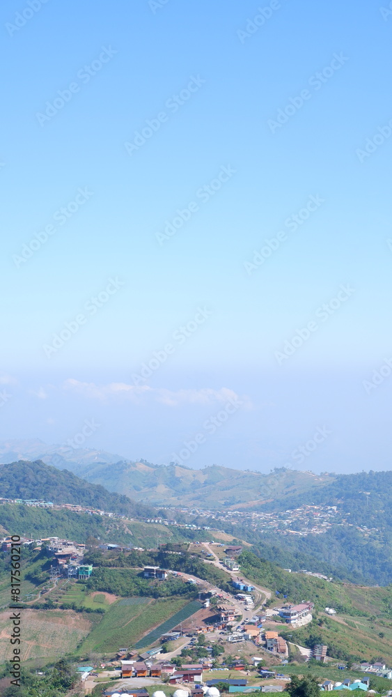 Naklejka premium Clear blue sky: With a touch of haze in the distance, suggesting a mountainous region.