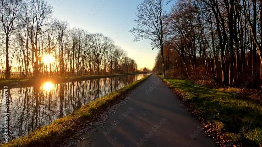 The sun is setting over a river lined with trees, creating a beautiful natural landscape with water reflecting the colorful sky The sun is setting over a river lined with trees, creating a beautiful natural landscape with water reflecting the colorful sky